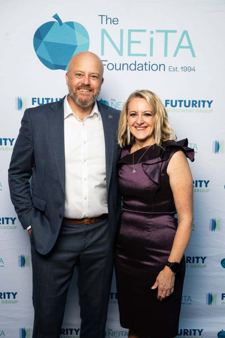 Westminster School Principal, Simon Shepherd and NEiTA Leadership Award winner, Angela Phillips standing together in front of a photo wall