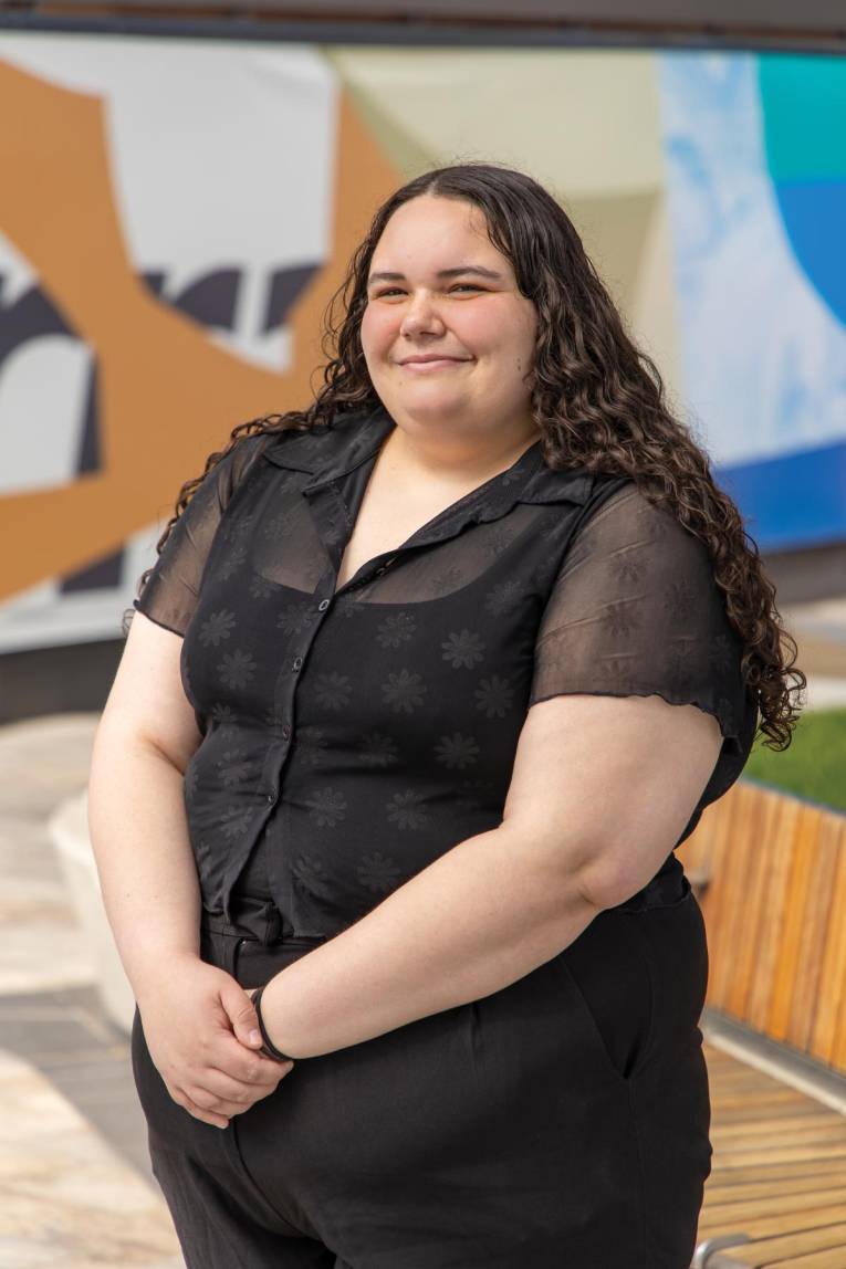 Photo of a person standing in a plaza