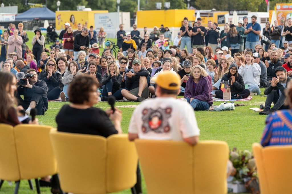 People sitting on yellow chairs and on the grass at Mourning in the Morning 2024 in Adelaide
