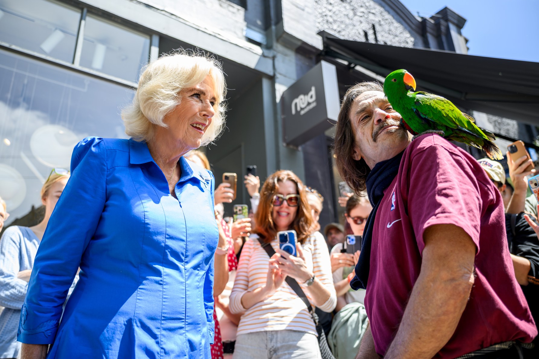 Britain's Queen Camilla (left) meets Pierre Gawronski and his parrot Caesar following her visit to Refettorio OzHarvest in Sydney, Tuesday, October 22, 2024. King Charles III and Queen Camilla are visiting Australia from 18 October to 23 October. (AAP Image/Bianca De Marchi) NO ARCHIVING