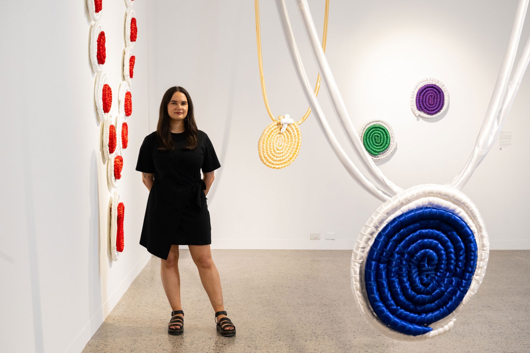 Carly Tarkari Dodd with her work 'Not Your Jewels!' in the 'Studios: 2024' exhibition at Adelaide Contemporary Experimental. Photo: Morgan Sette