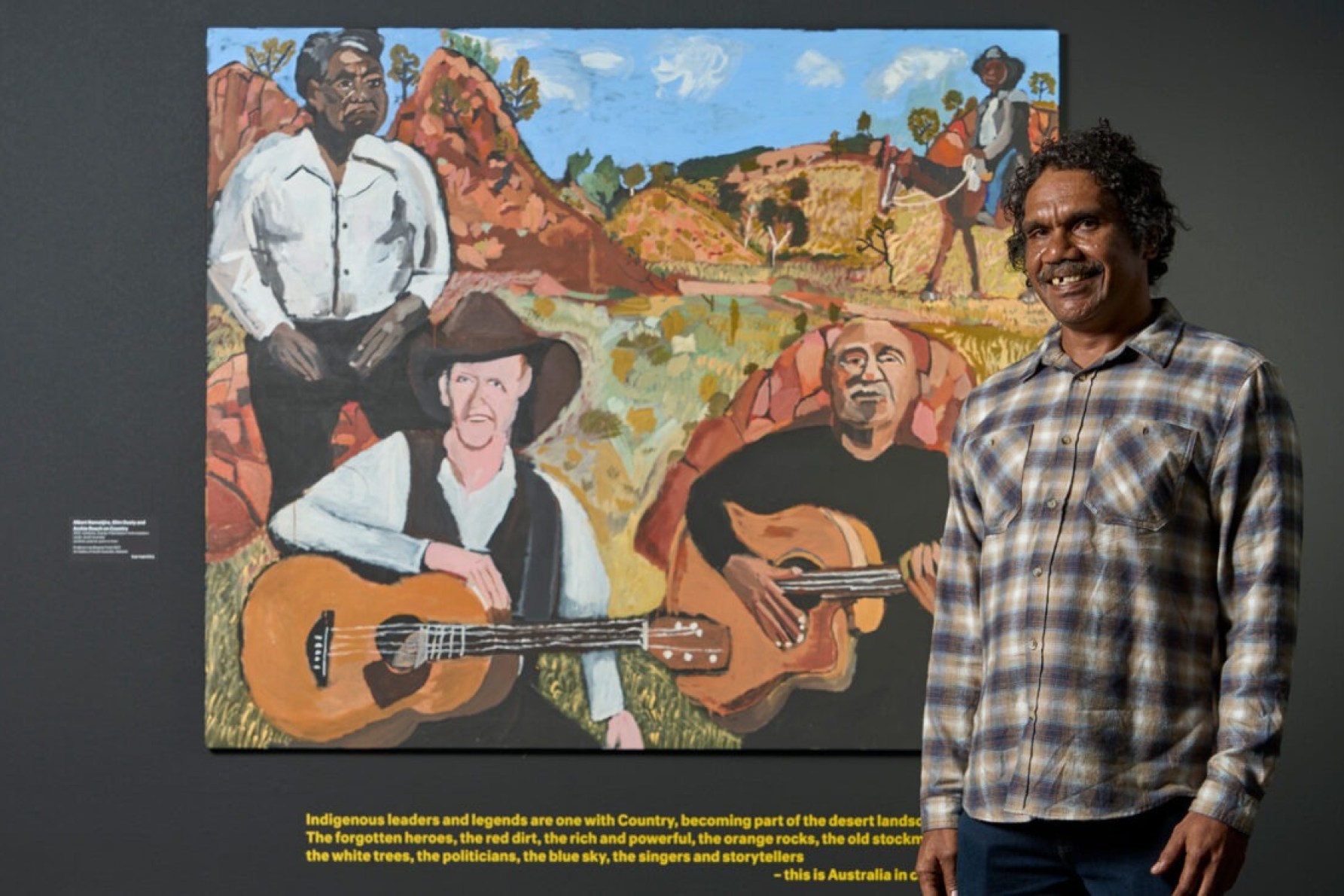 Vincent Namatjira with his work 'Albert Namatjira, Slim Dusty and Archie Roach on Country' in 'Vincent Namatjira: Australia in colour' at the Art Gallery of South Australia. Photo: Sam Roberts / supplied