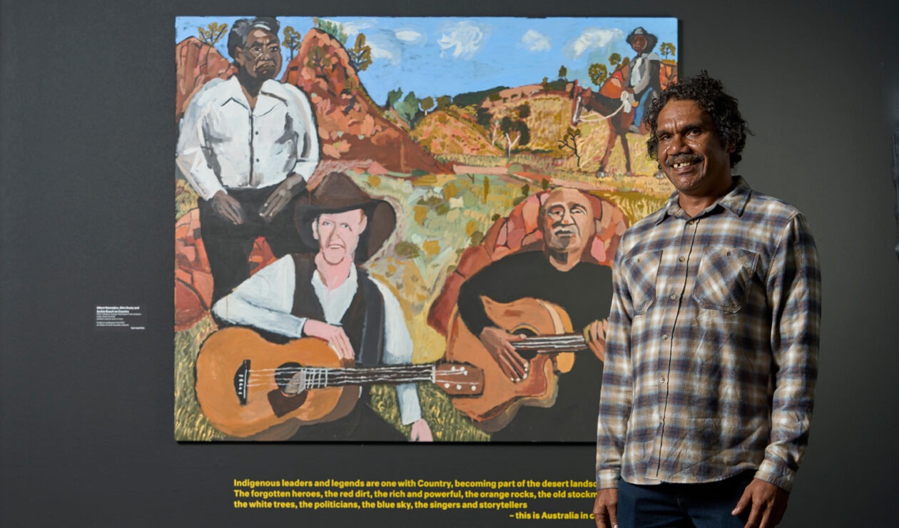 Vincent Namatjira with his work 'Albert Namatjira, Slim Dusty and Archie Roach on Country' in 'Vincent Namatjira: Australia in colour' at the Art Gallery of South Australia. Photo: Sam Roberts / supplied