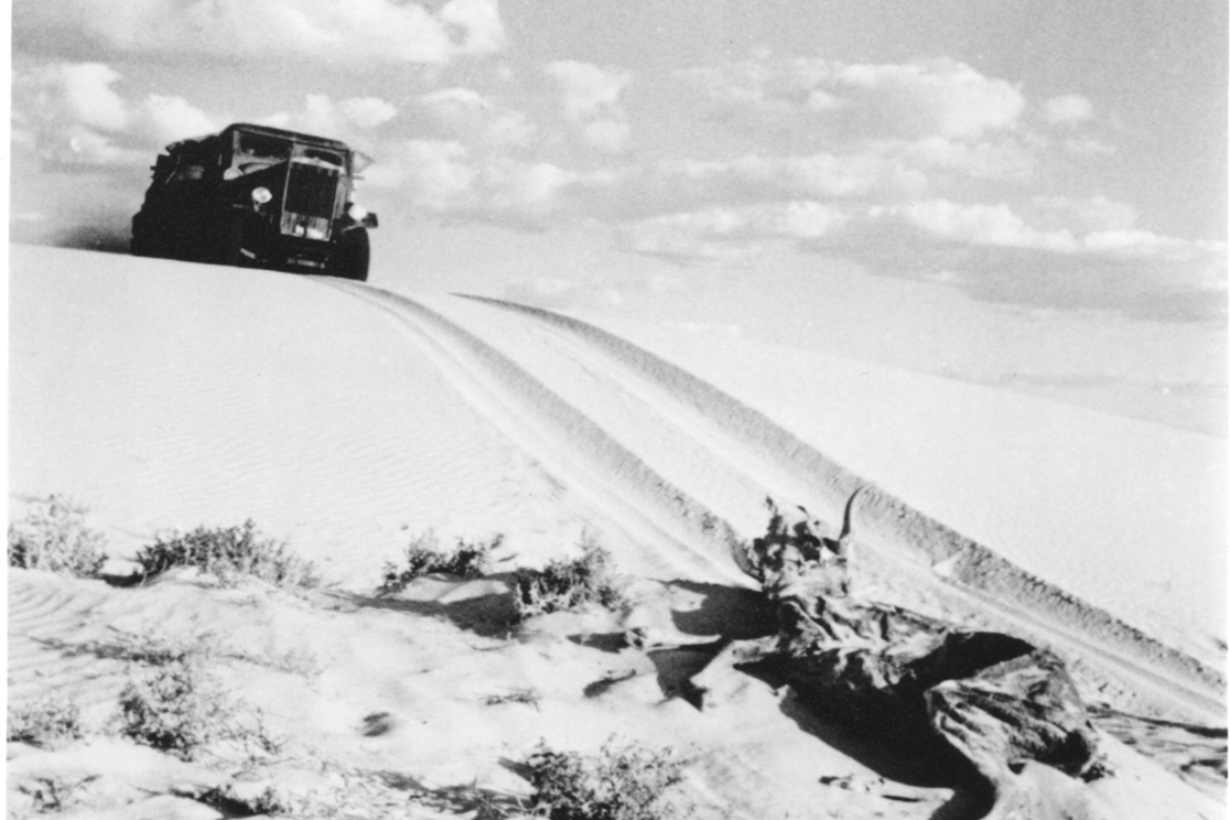 Tom Kruse and his 1936 Leyland Badger navigate sandhills on their outback delivery in the film Back of Beyond. Supplied: The Tom Kruse Collection