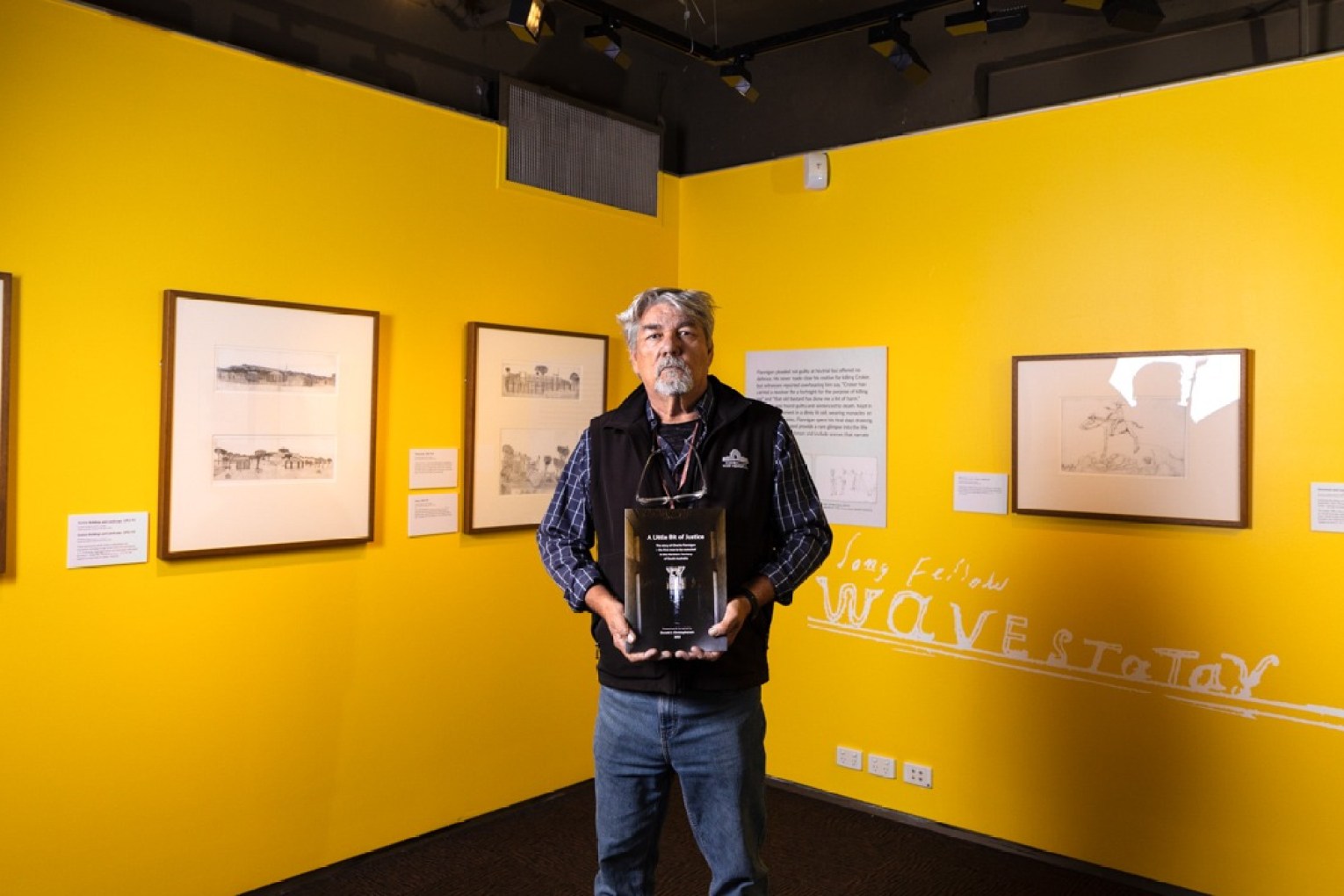 Donald Nawurlany Christophersen holding his book 'A Little Bit of Justice', taken by Sia Duff.