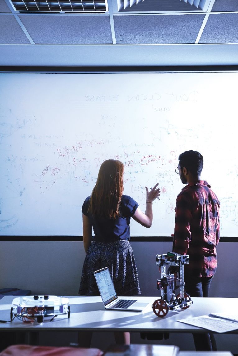 Two mathematical sciences students at Adelaide University working on a whiteboard