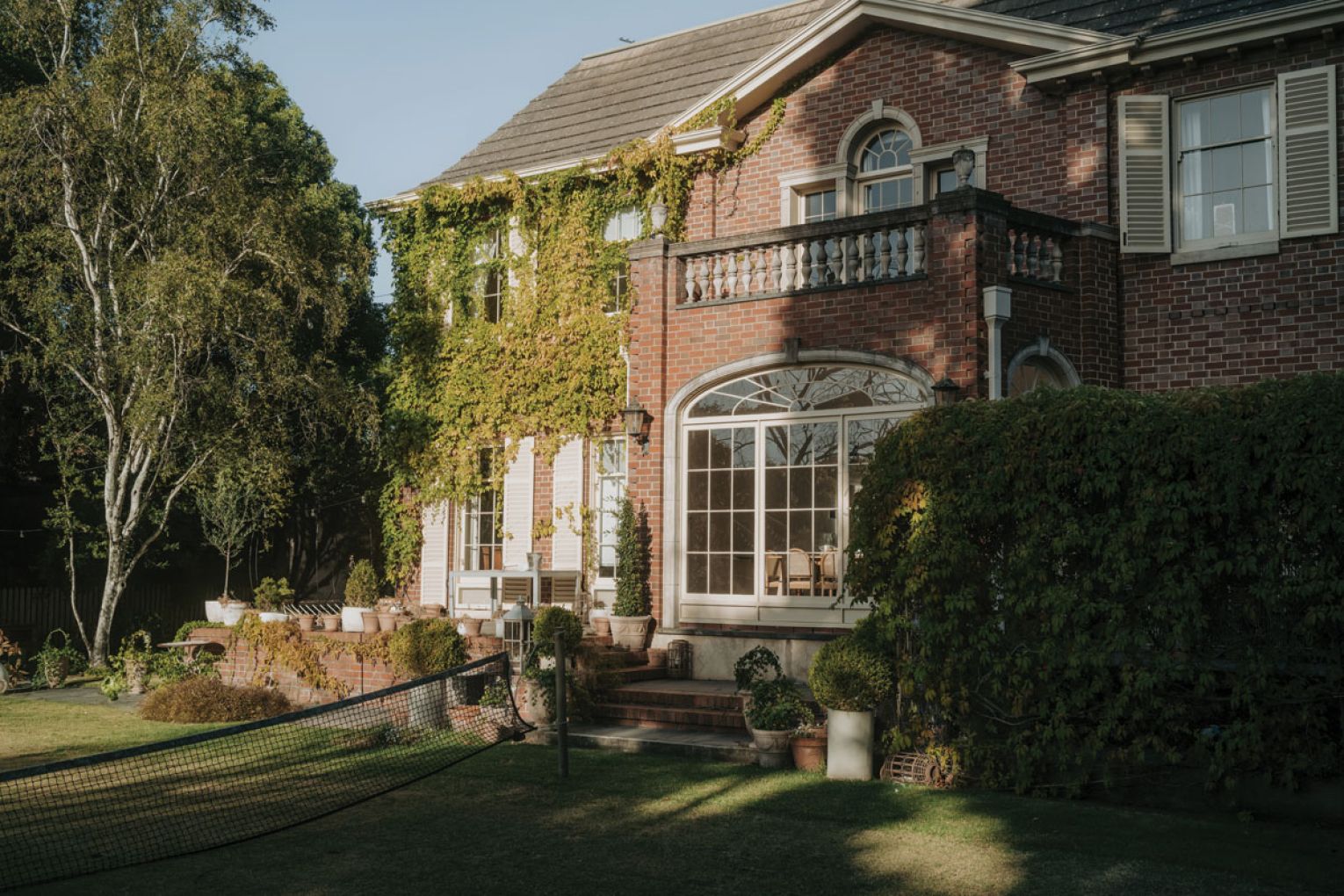 A view of the back of the home showing one of the couple’s favourite elements, the balcony overlooking the lawn tennis court.