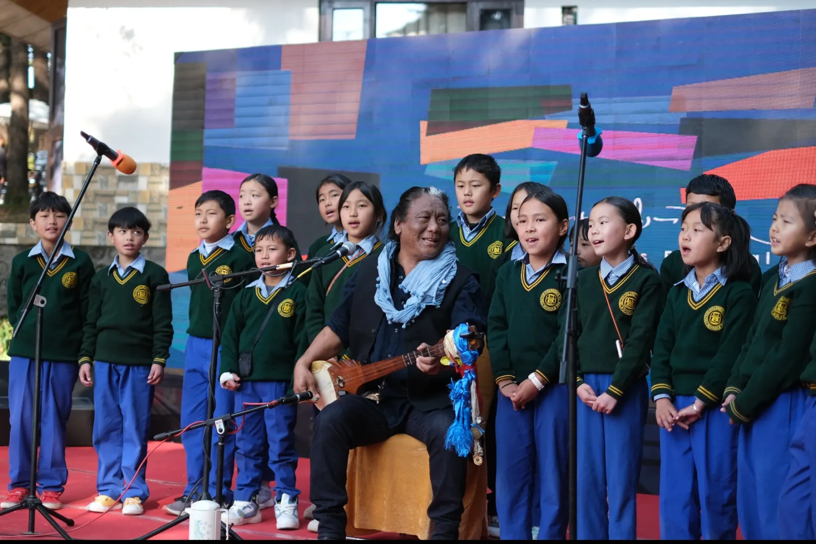 Tenzin Choegyal performing with pupils from the Tibetan Children’s Village in Dharamshala, India. Photo:  Jamyang Tenzin