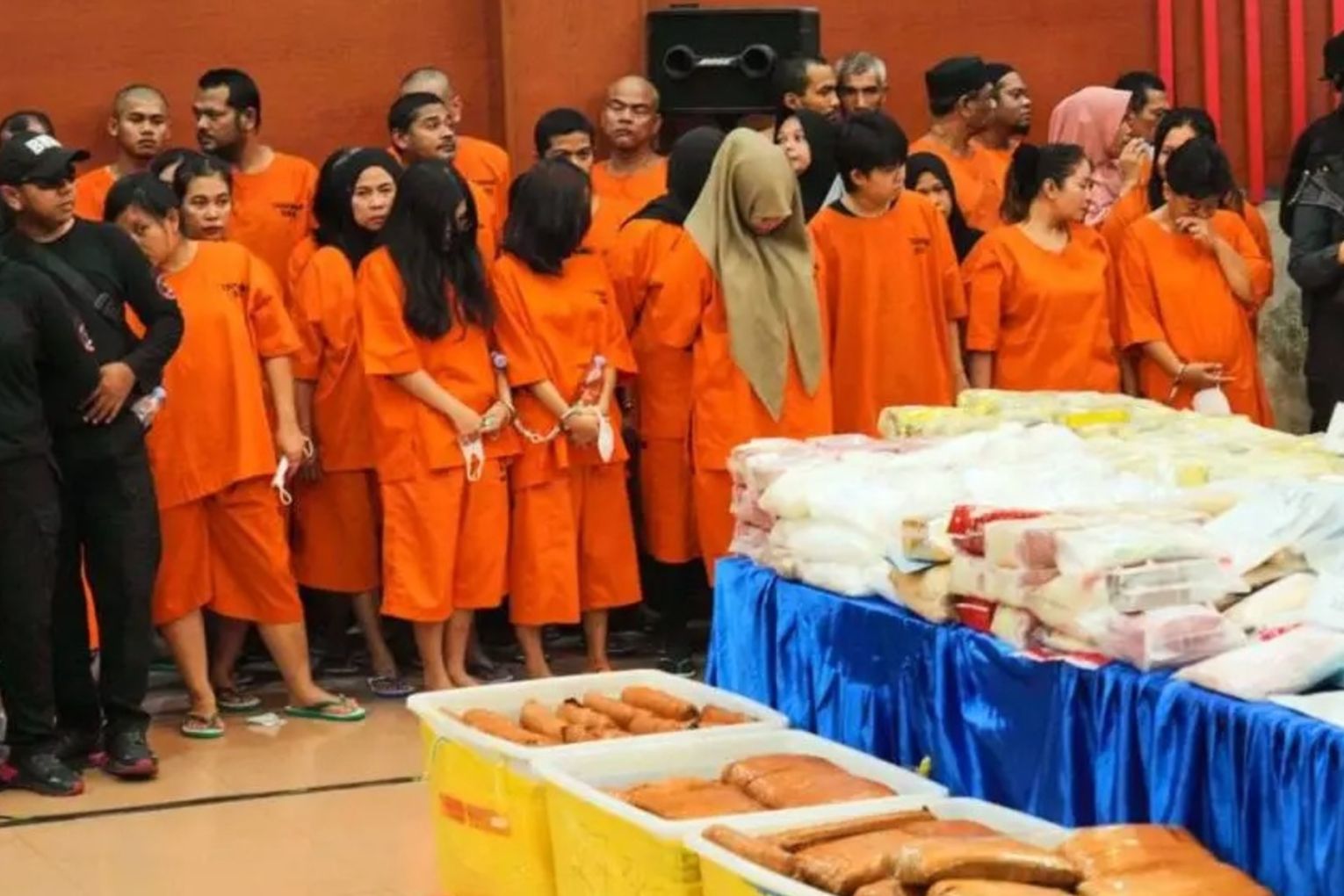 Drug suspects in orange prison uniforms and confiscated drugs have been presented by authorities.