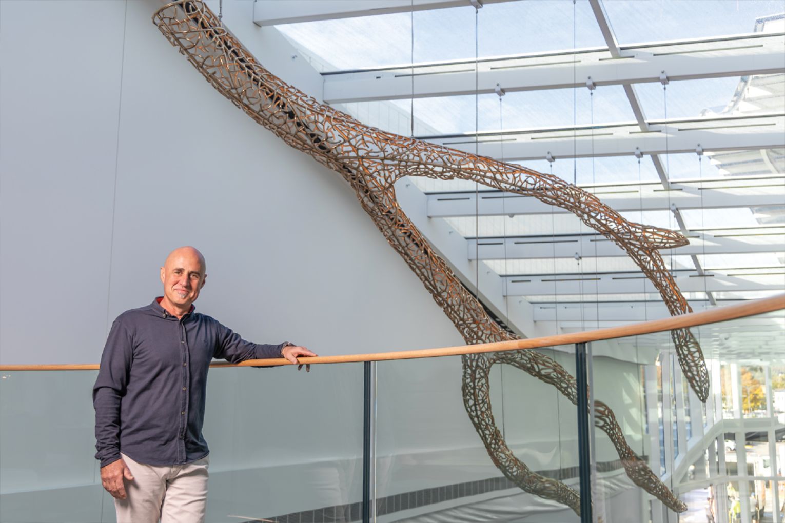 Artist Peter Syndicas with the one-tonne, 11-metre-long Celestial Lifeform, hanging in the newly-developed Burnside Village. Photograph Ben Kelly