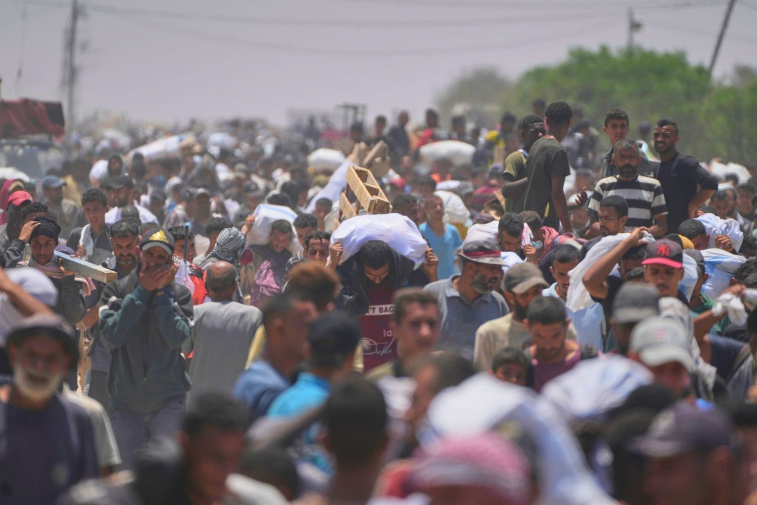 Palestinians carry bags containing food and humanitarian aid packages delivered by the Gaza Humanitarian Foundation, a U.S.-backed organization, in Rafah, southern Gaza Strip, Monday, June 9, 2025. Photo: AP/Abdel Kareem Hana