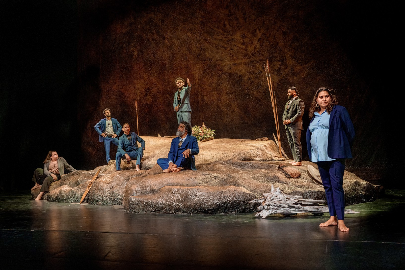 Starring in The Visitors are (left to right) Zoe Walter, Stephen Geronimos, Sean Dow, James Slee (grey suit), John Blair, Beau Dean Riley Smith, and Dalara Williams.