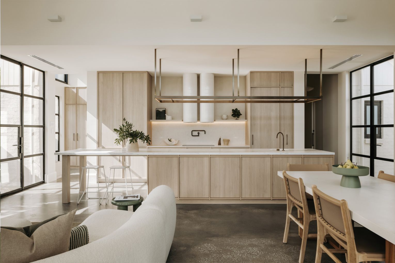 A focal point of the new kitchen is the statement gantry, which provides subtle lighting. The home office, connected by large glass steel-framed doors, can be seen to the right.