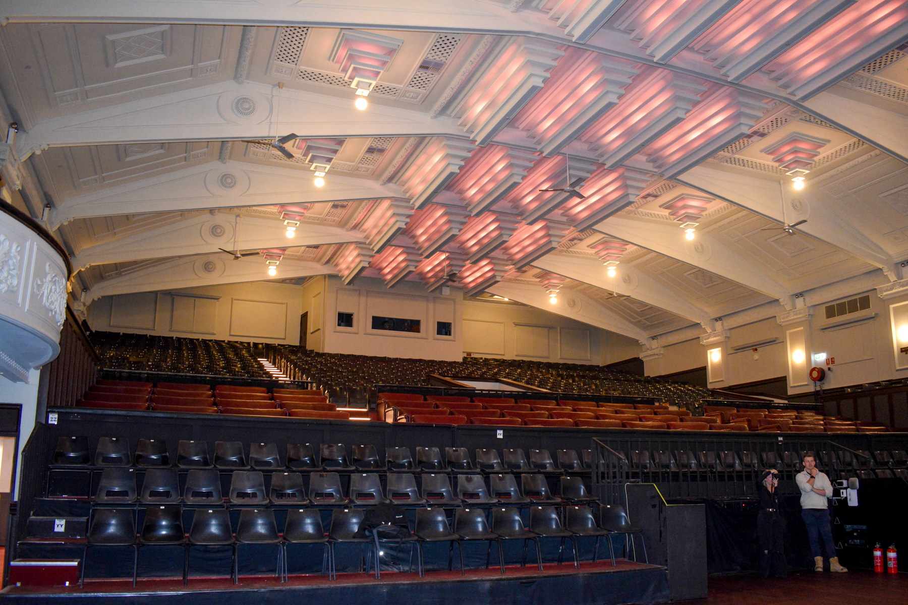 Black seats, with a row of love seats behind the thebby theatre
