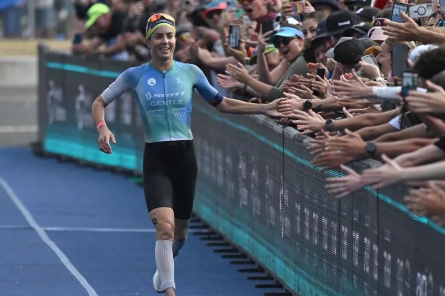 Ashleigh Gentle, high-fiving fans in Wollongong, will miss the Noosa Triathlon she has dominated. Picture: Dean Lewins/AAP Photos