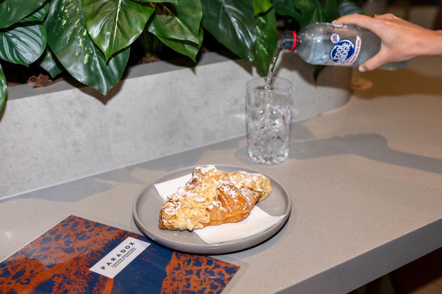 Indulge in an almond croissant with a bottle of water for $11 at Paradox Coffee Roasters. Credit: Jade Quinlivan Photography