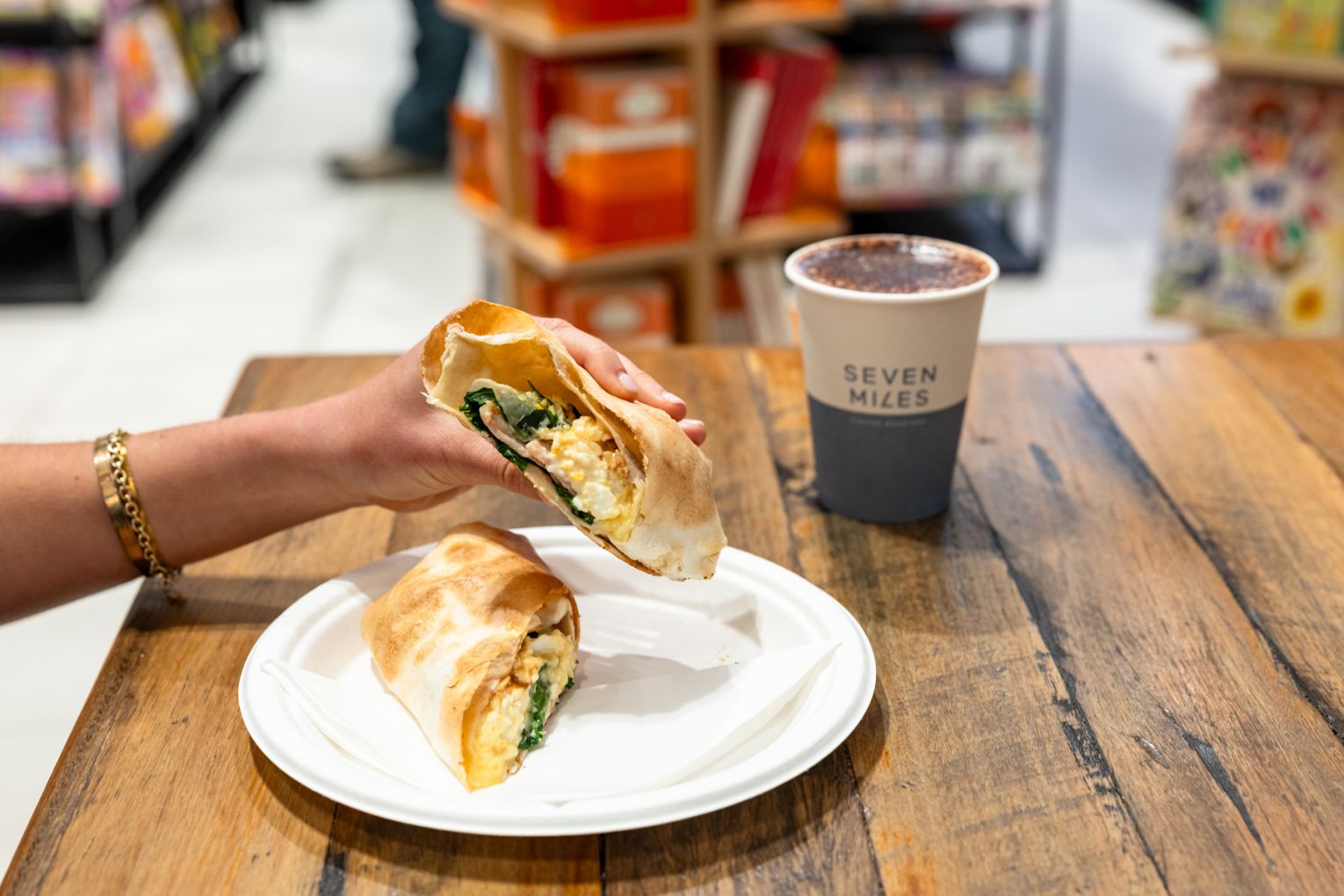 Grab a bacon-and-egg wrap and barista-made coffee for $11 from The Book Cellar. Credit: Jade Quinlivan Photography