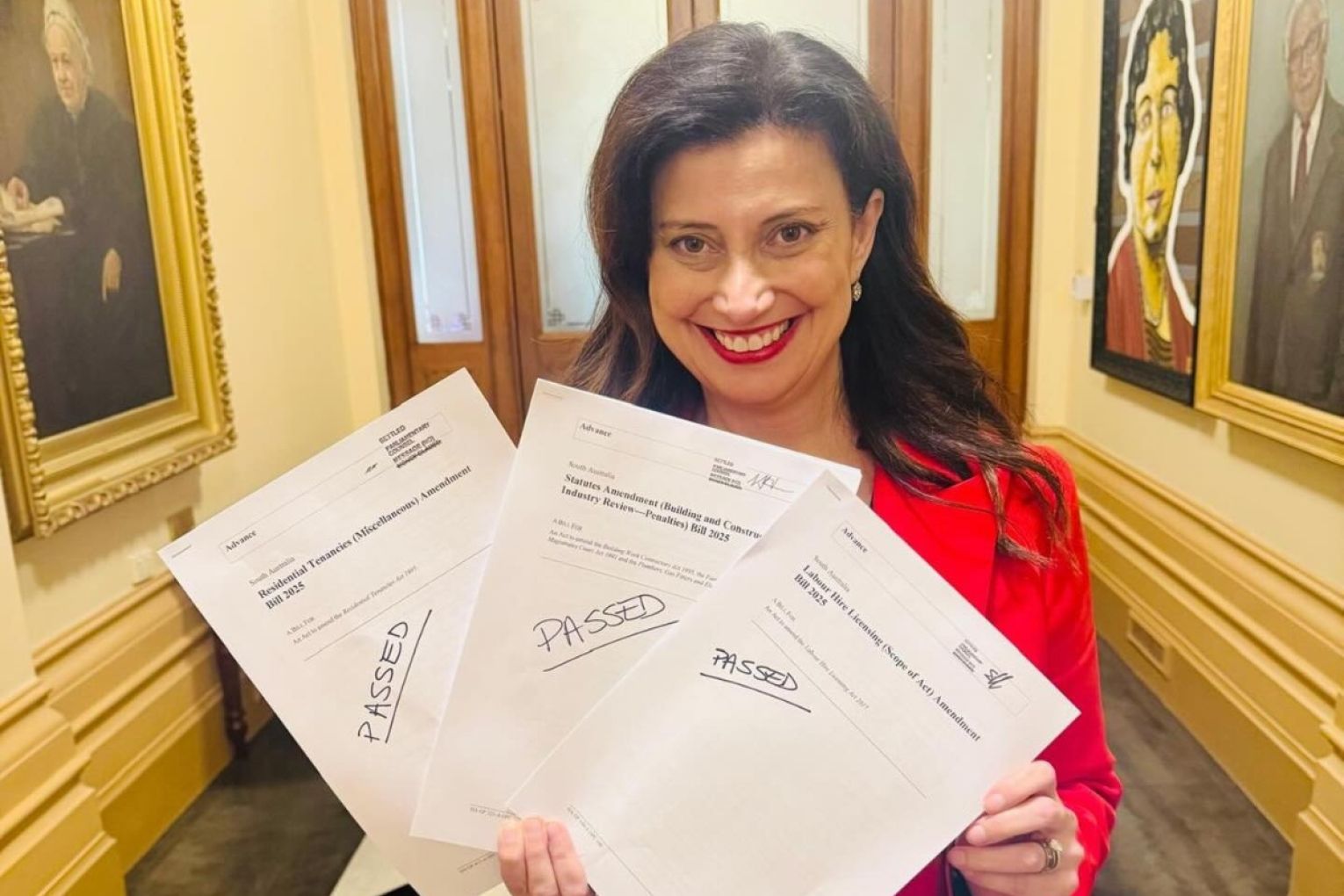 Andrea Michaels posing with bills the state government passed in November 2025. Photo: via Facebook
