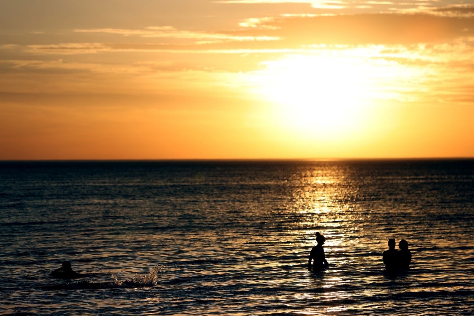 Beachgoers during hot weather at Glenelg beach in Adelaide, Wednesday, December 18, 2019. AAP Image/Kelly Barnes
