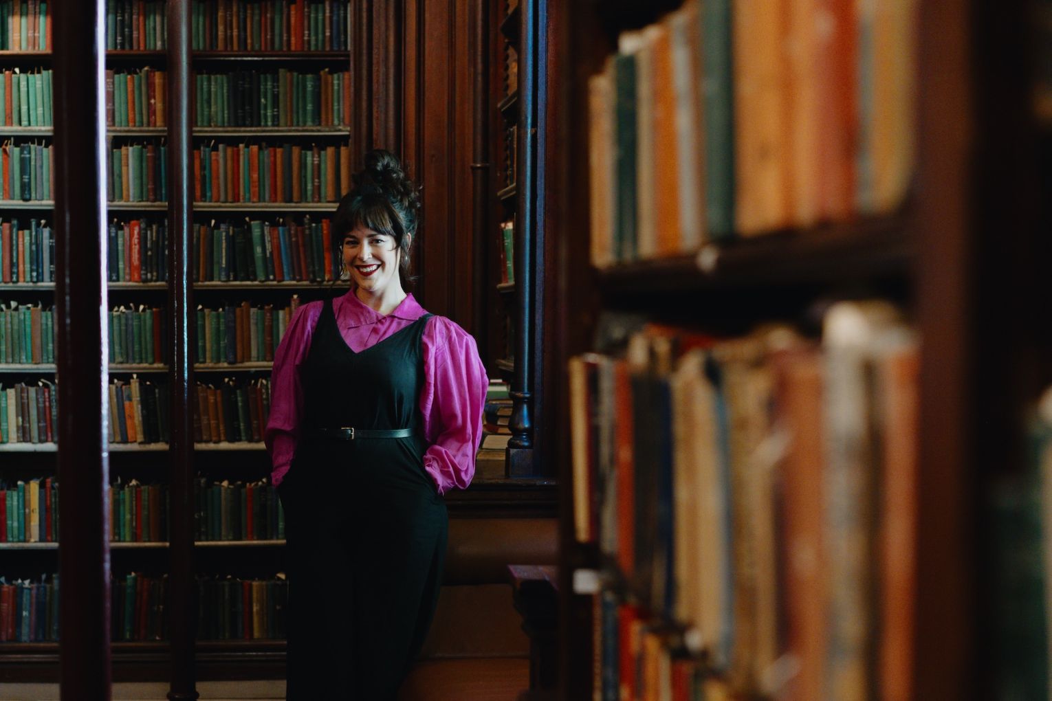 Performer and producer Britt Plummer in the Circulating Library of the State Library of South Australia, one of several spaces transformed into pop-up Fringe venues as part of The Courtyard of Curiosities. Photo: Ramsay Taplin / Supplied