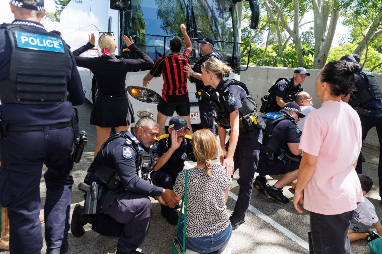 Protesters are seen demonstrating outside of Royal Pines resort as a bus carrying Iranian players and staff departs. Iranian soccer players who received humanitarian visas after staging an on-pitch protest against their country's regime, are seen at Royal Pines resort on the Gold Coast, Queensland. Picture: AAP Image/Russell Freeman