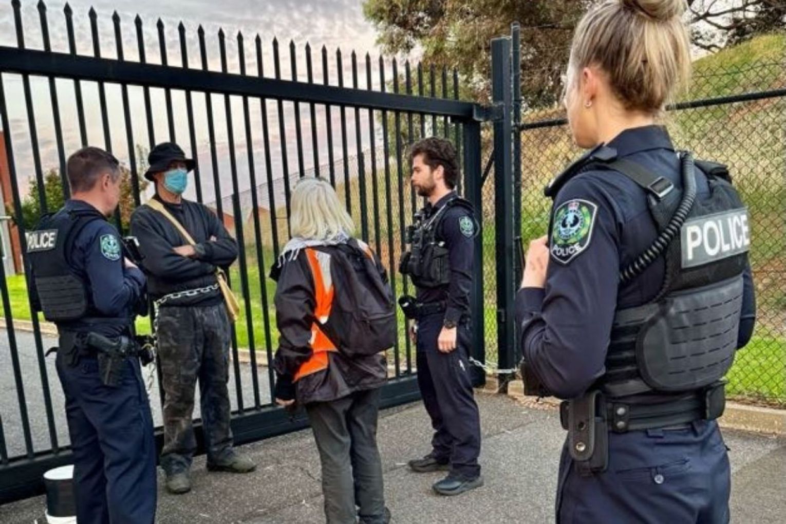 A protester locked himself to the gates of an Adelaide-based defence manufacturing facility this morning. Pictures: supplied.