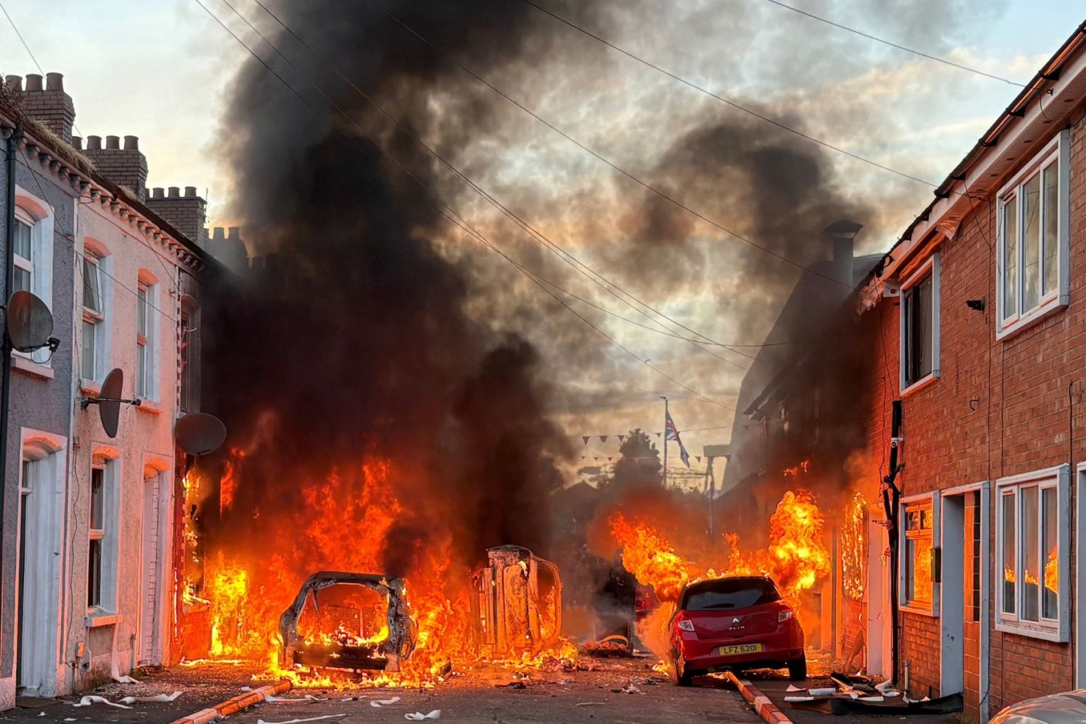 Vehicles set on fire by protesters burn on Lendrick Street in east Belfast, Northern Ireland, on Tuesday, June 9, 2026, after the arrest of a Sudanese man accused of stabbing a man in the northern part of the city. Picture: PA via AP