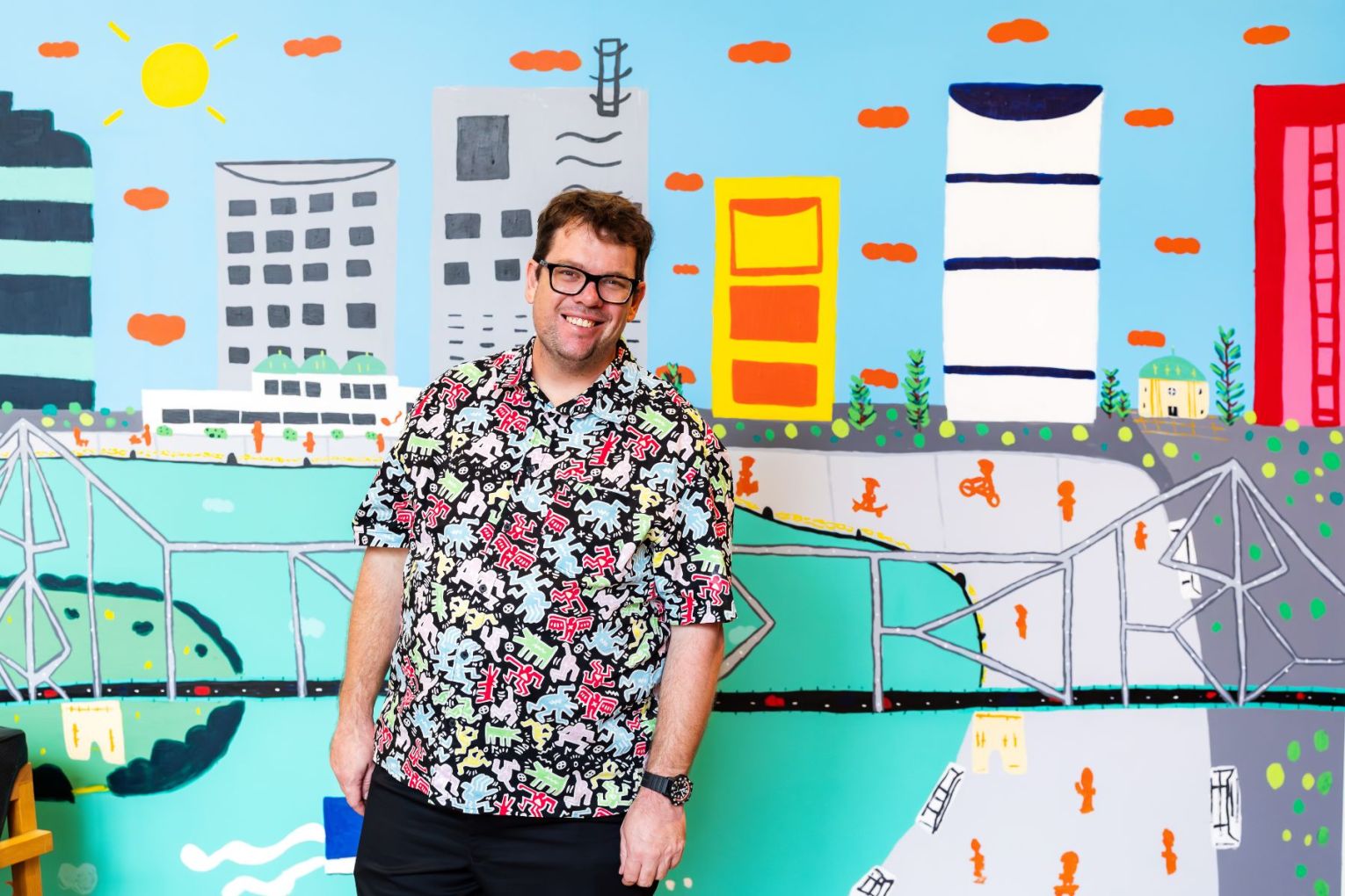 Museum of Brisbane  artist-in-residence Martin Edge at the museum, pictured with one of his colourful murals.
Photo: Katie Bennett