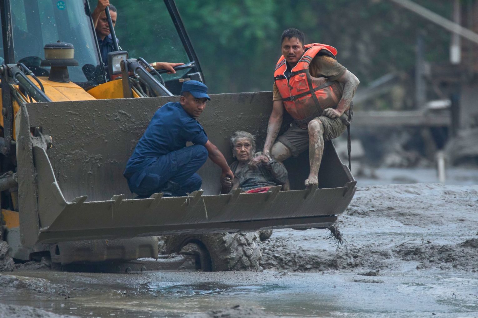 Rescuers use an earthmover to carry a victim of flash flooding to safety along the Trishuli River in Nepal's Nuwakot district on Wednesday. Picture: AP/Niranjan Shrestha)