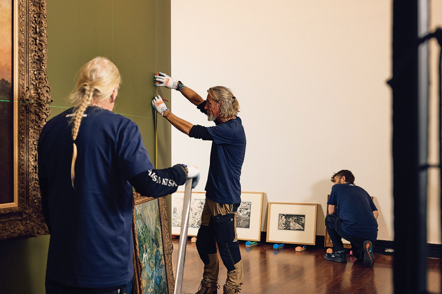The install team at work, and Camille Pissarro’s Peasants Resting.