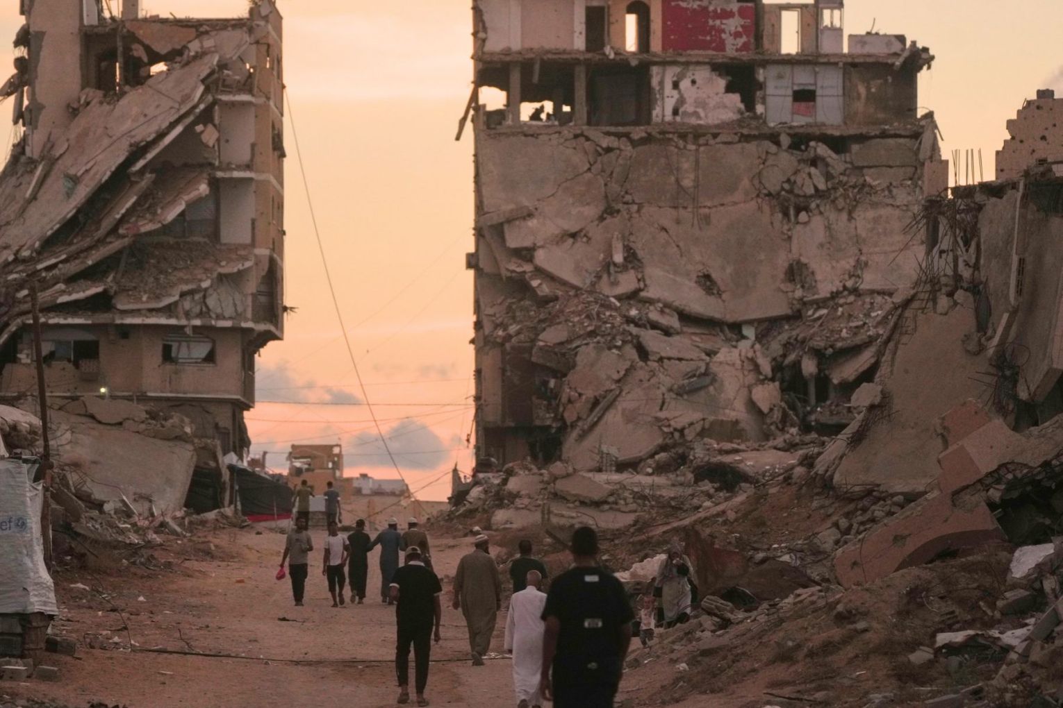 Palestinians walk along a street surrounded by buildings destroyed in Israeli military strikes during the Israel-Hamas war in Gaza City. Tuesday, October 6. Picture: AP Photo/Jehad Alshrafi